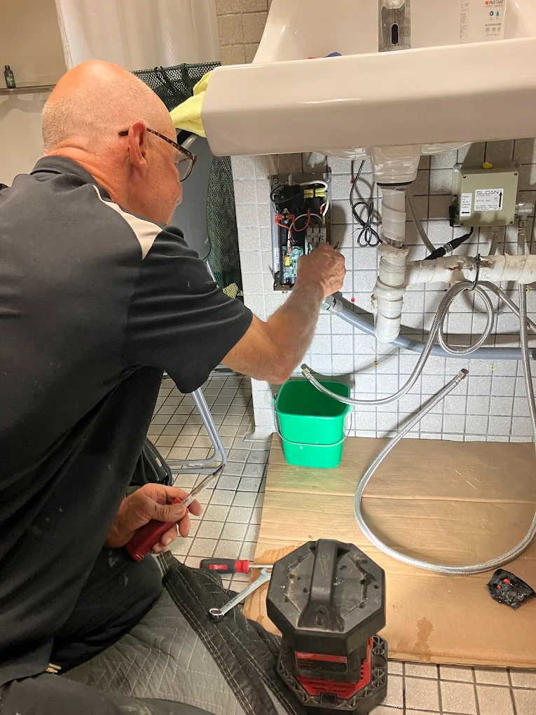 AAA Paradise Plumbing technician installing a fixture under a sink in Ventura, CA